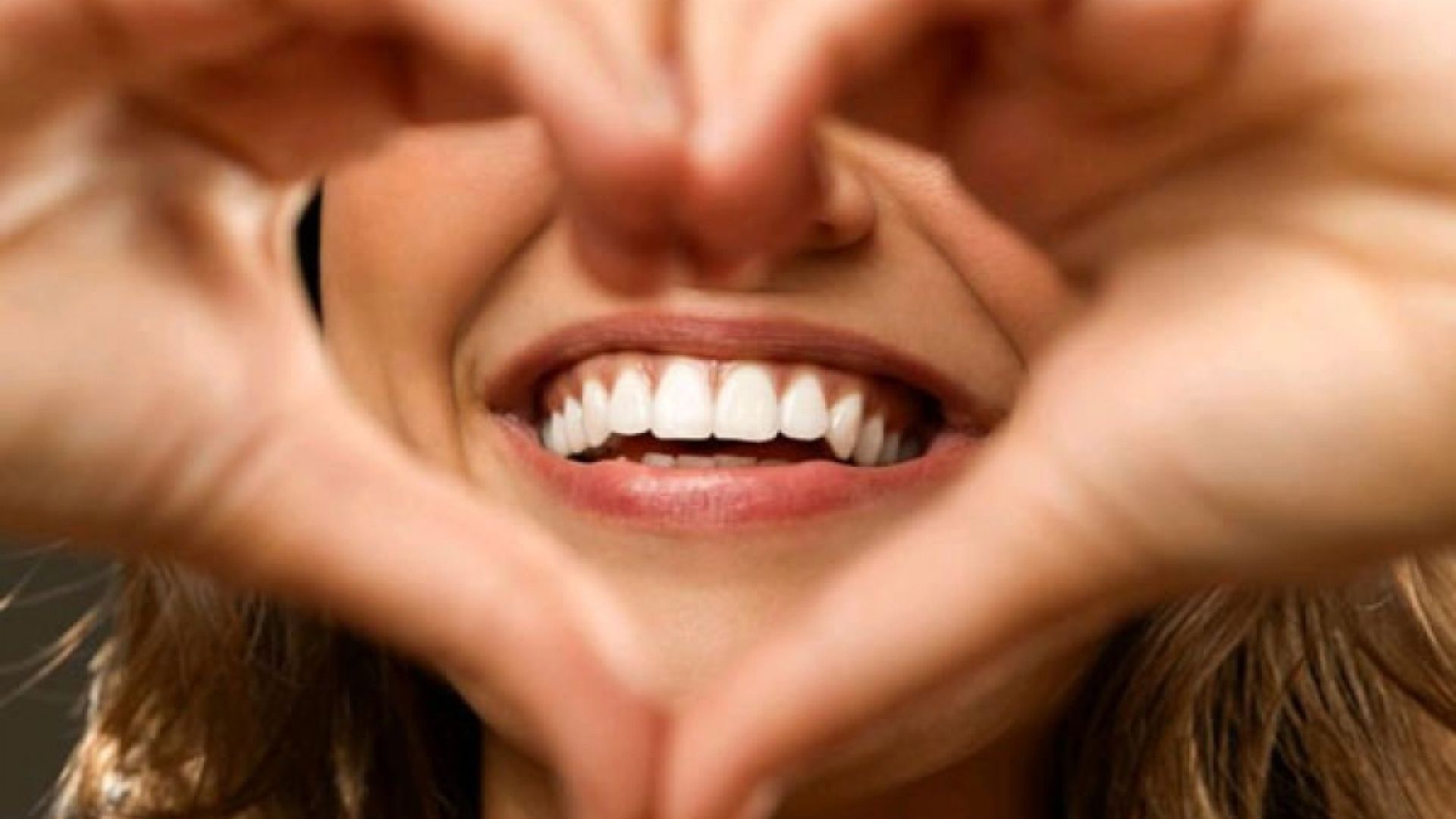 Smiling woman making a heart shape with her hands